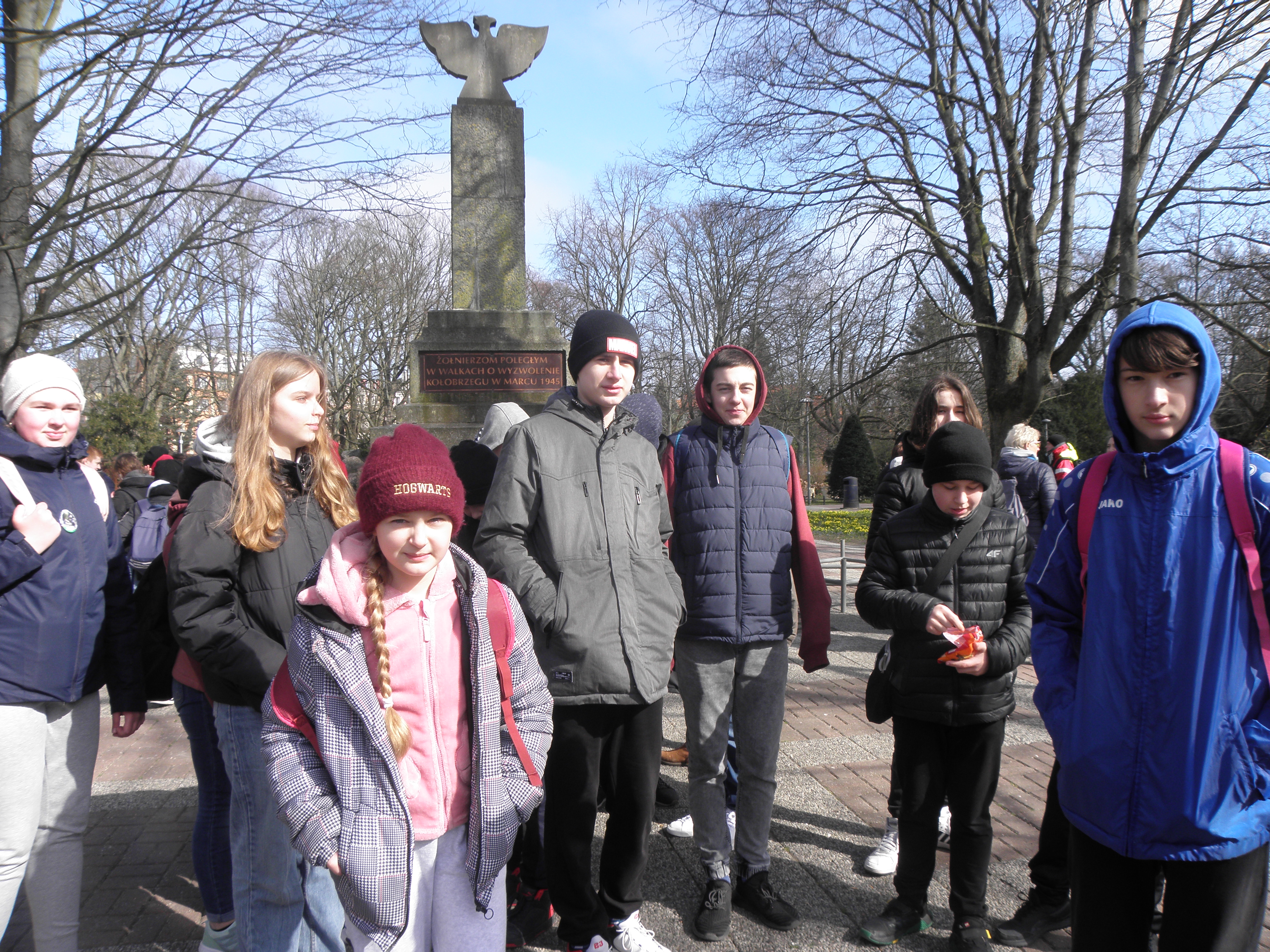 uczniowie biorący udział w marszu PTTK pod pomnikiem walk o Kołobrzeg