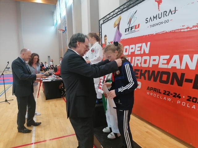 Grafika przedstawia wręczenie medali w międzynarodowych zawodach o Puchar Europy Taekwon-Do ITF 