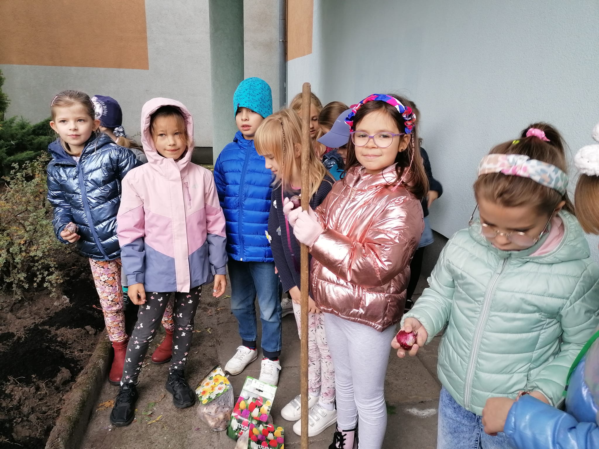 dzieci sadzą cebulki pod szkołą