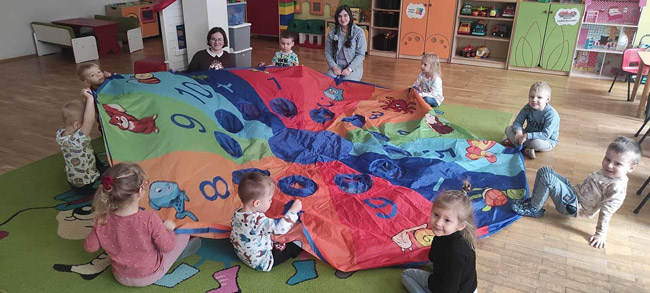 Trzy uczennice klas ósmych podczas zzabawy z przedszkolakami