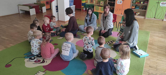 Trzy uczennice klas ósmych podczas zabawy z przedszkolakam