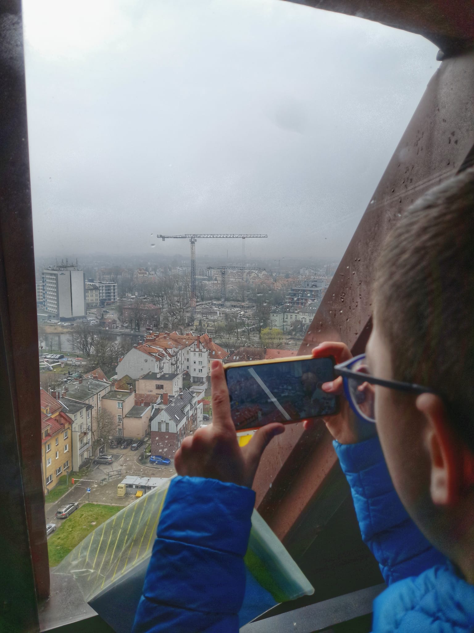 uczeń wykonuje fotografię przez okno na wieży bazyliki