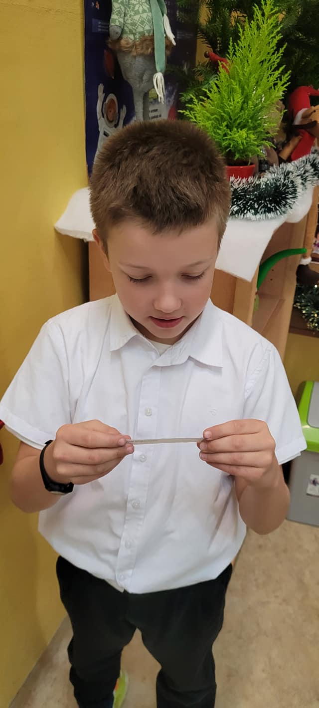 Chłopiec odczytuje zadanie z kalendarza adwentowego.