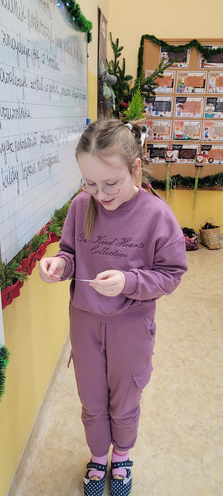 Dziewczynka odczytuje zadanie z kalendarza adwentowego.