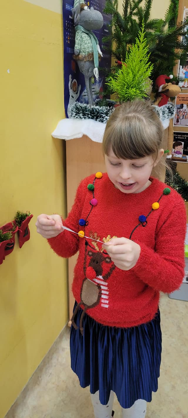 Dziewczynka odczytuje zadanie z kalendarza adwentowego.