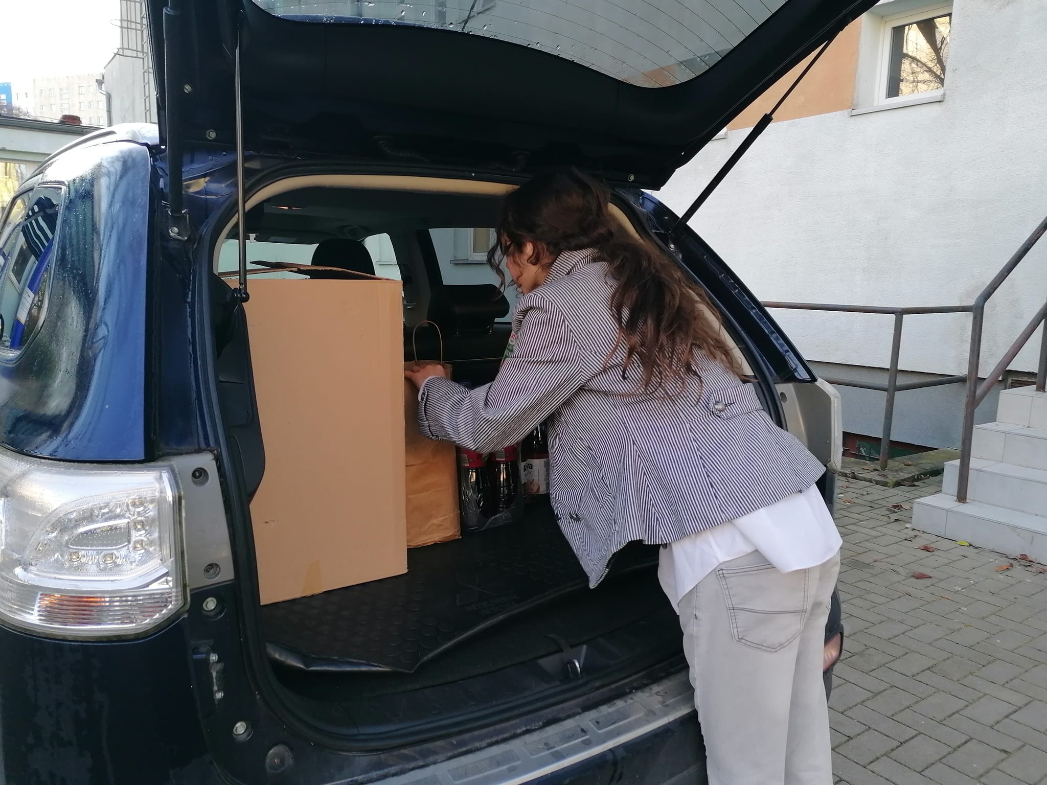 Wolontariusze chowają dary do samochodu.