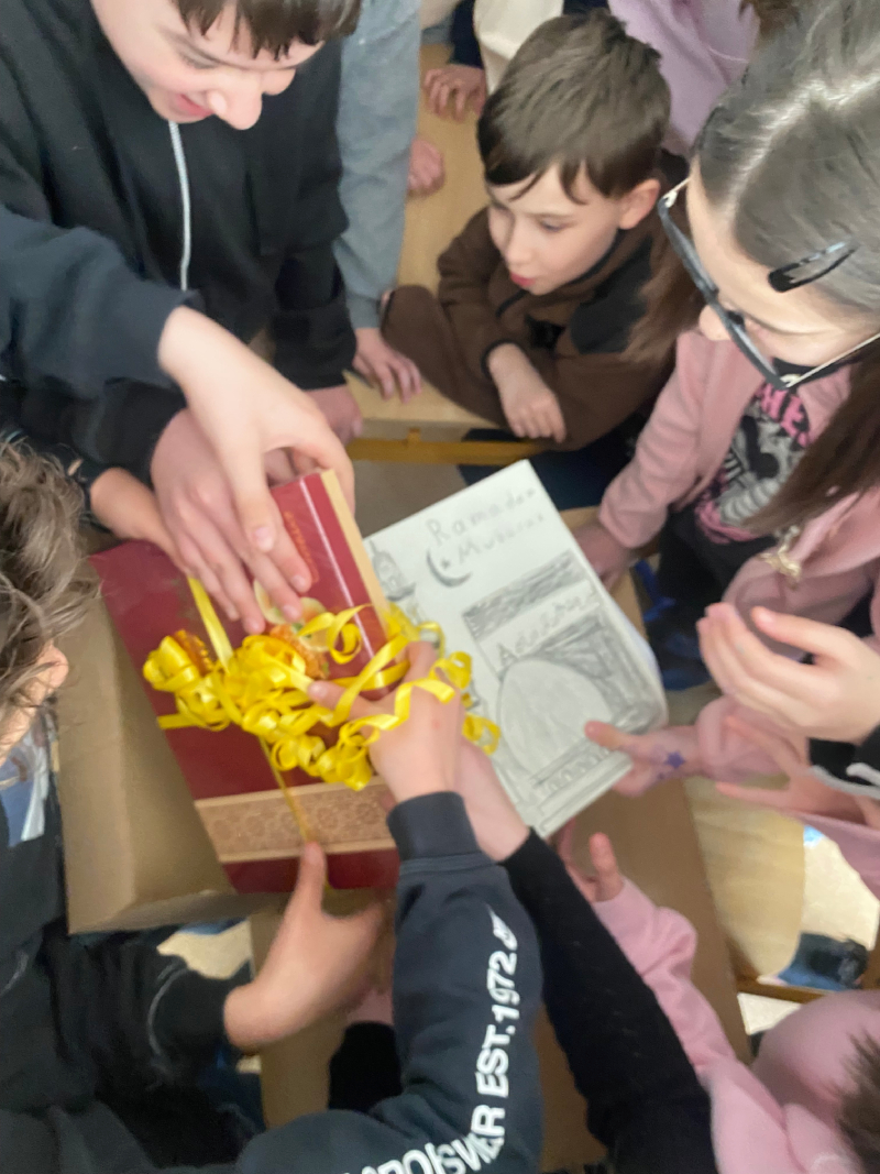 Uczniowie rozpakowują paczkę od dzieci z niemiec